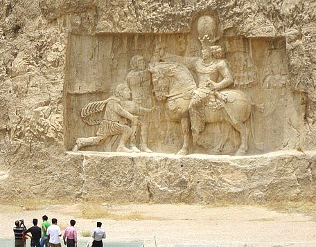 император Валериана в виде пленника, склонившегося перед персидским царем. Этот барельеф составляет часть комплекса Нагше-Ростам8